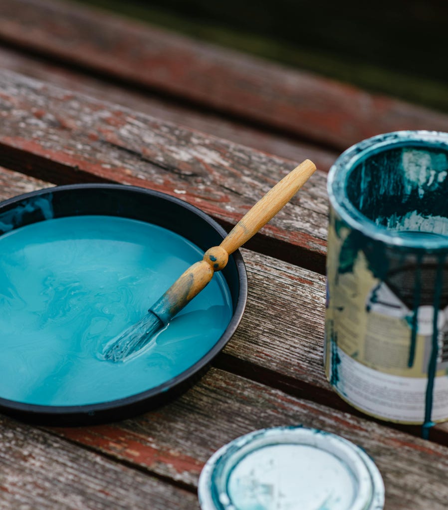 Bowl of paint near jar on bench