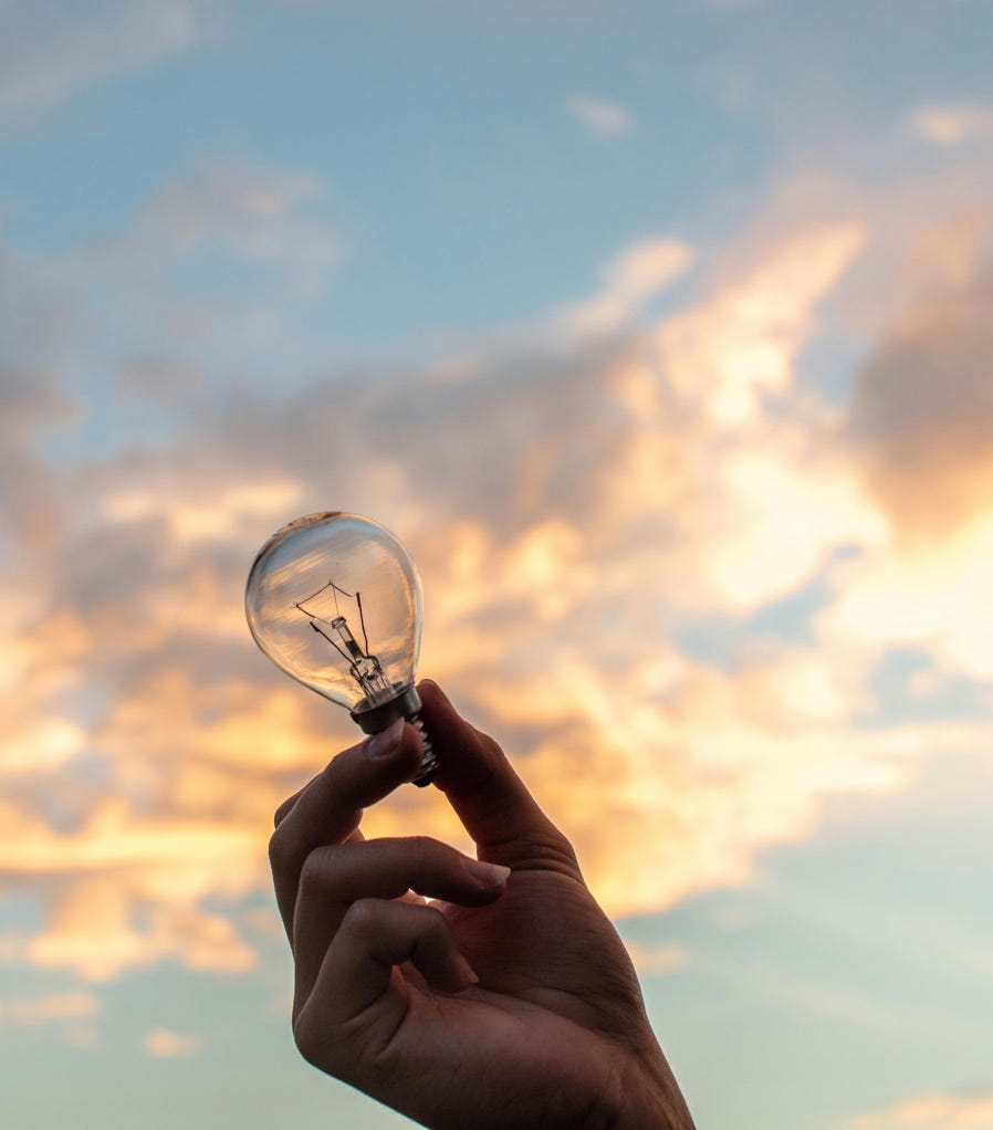 Person Holding Clear Light Bulb